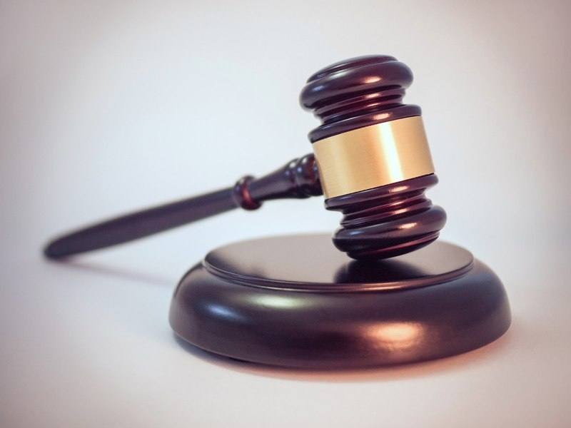 An auctioneer's gavel resting on its sound block