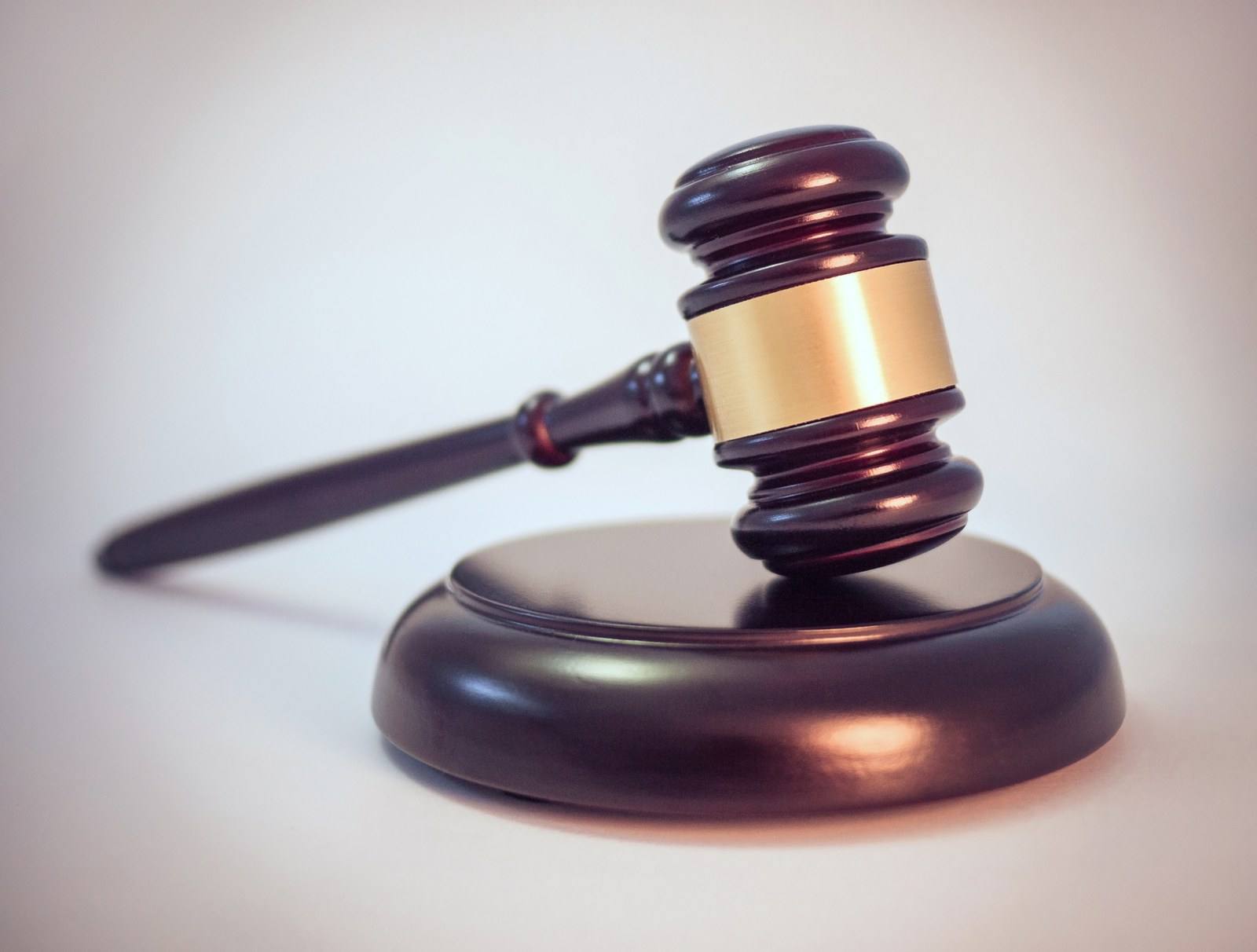 An auctioneer's gavel resting on its sound block