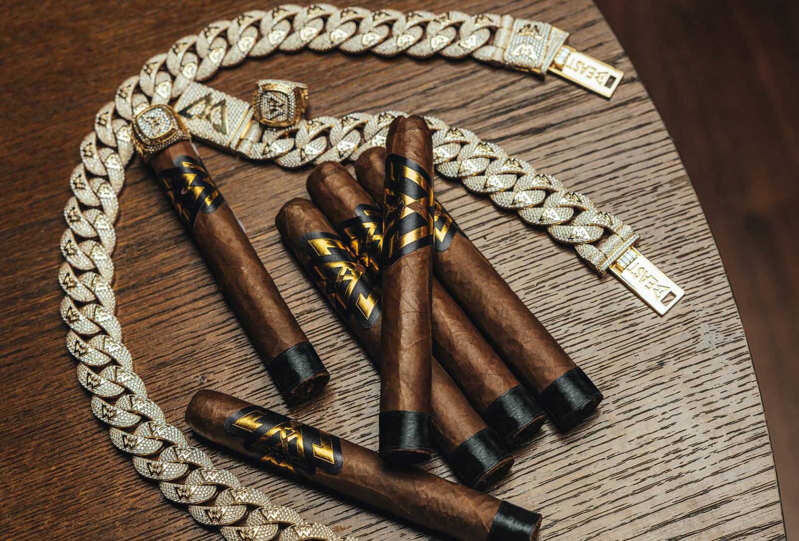 Beast Mode by Kingmakers cigars with their gold and black bands, photographed beside a chunky Beast-tagged chain