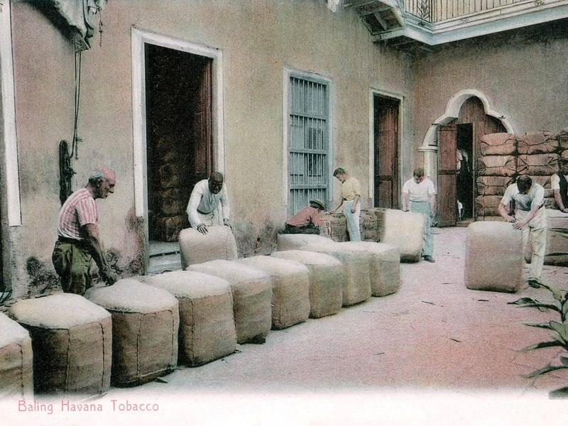 Workers handling bales of Havana tobacco in a courtyard