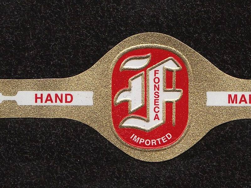 An ornate gold and red cigar band