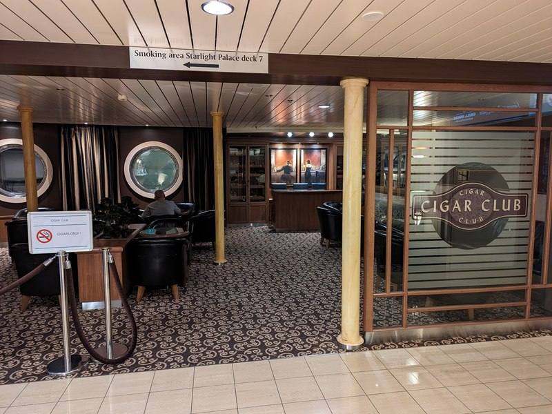 Cigar bar seating area with leather armchairs and a humidor cabinet