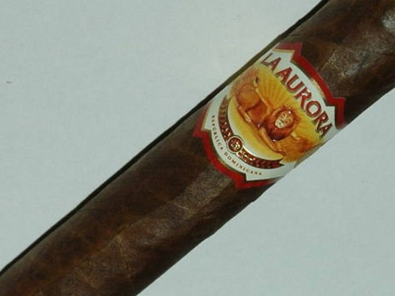 A La Aurora cigar with its band, photographed on a light background