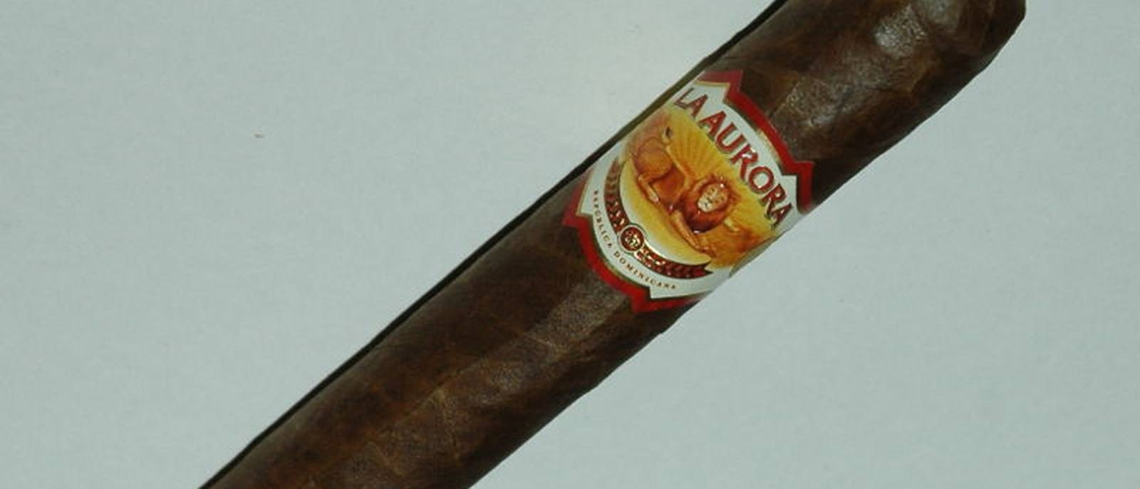 A La Aurora cigar with its band, photographed on a light background