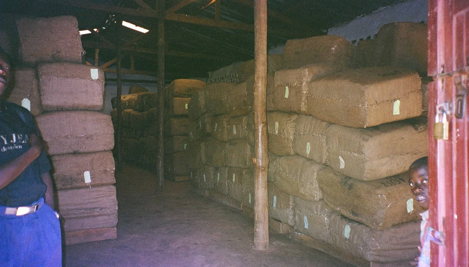 Bales of tobacco stacked floor to ceiling in a village warehouse