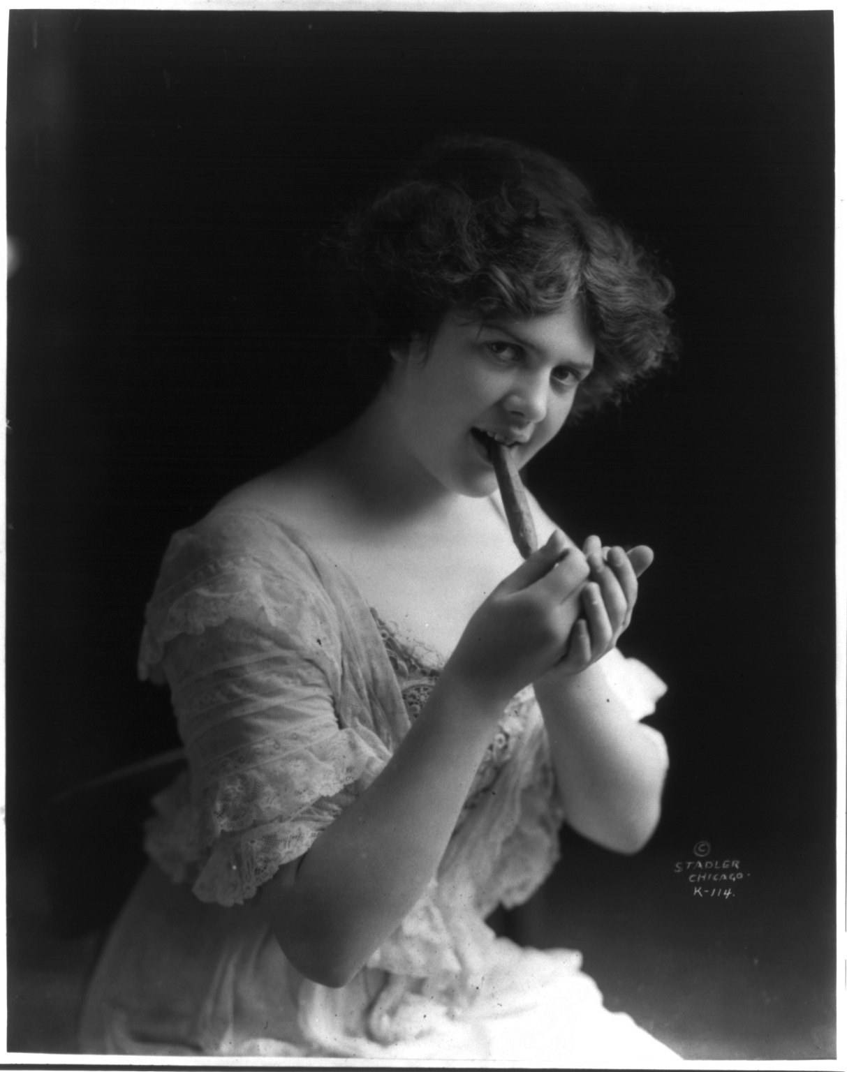 A young woman lighting a cigar
